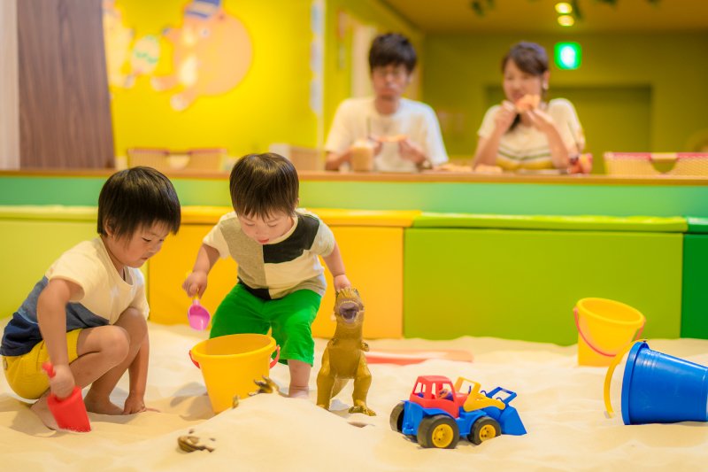 お子様が室内砂場に夢中になっている時、大人は座ってのんびりと